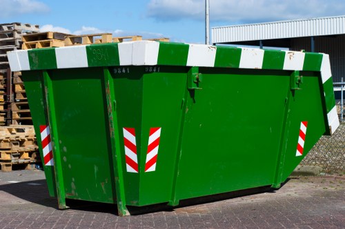 Crew standing beside a skip with safety gear and paperwork
