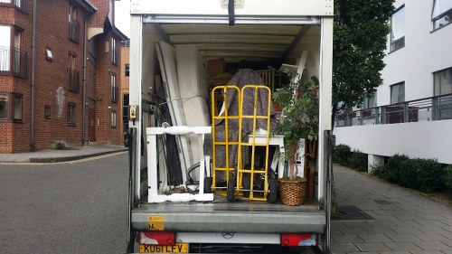 Workers loading construction debris into a lockable skip