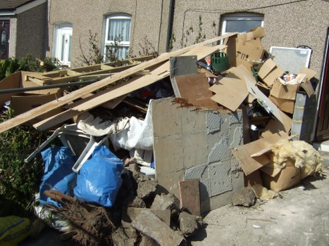 Professional skip hire company vehicle unloading a skip